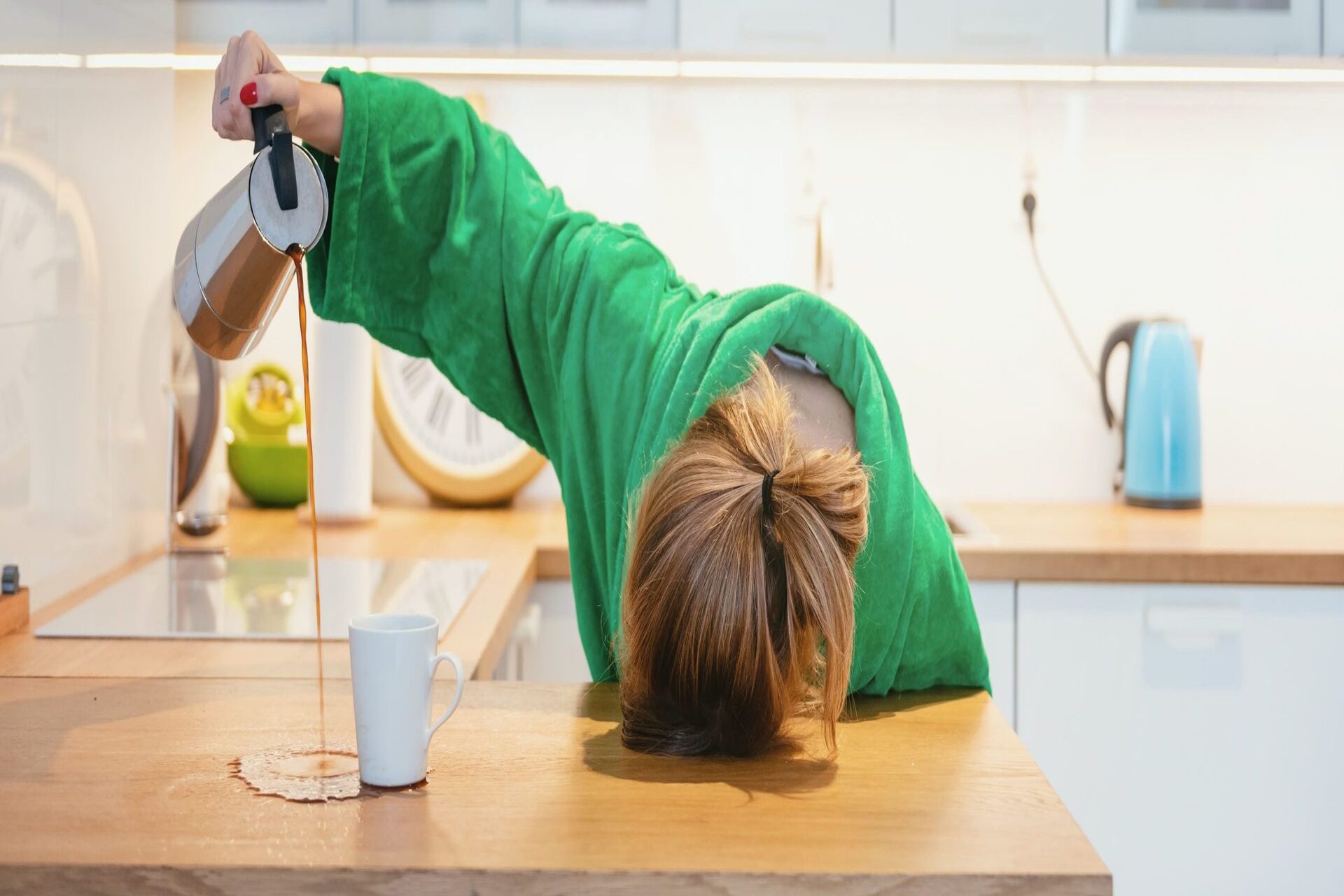 stock-photo-tired-woman-sleeping-on-the-table-in-the-kitchen-at-breakfast-trying-to-drink-morning-coffee-1211071171-scaled-e1684423047956.jpg